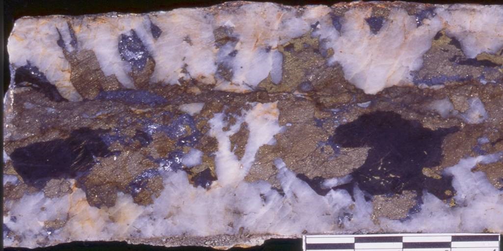 PLATE 30b : Kidston sheeted vein gold mineralisation. Close up of vein, showing medium grained, comb textured quartz crystals lining vein margin with later iron carbonate, pyrite and base metal sulphide filling vein cores.