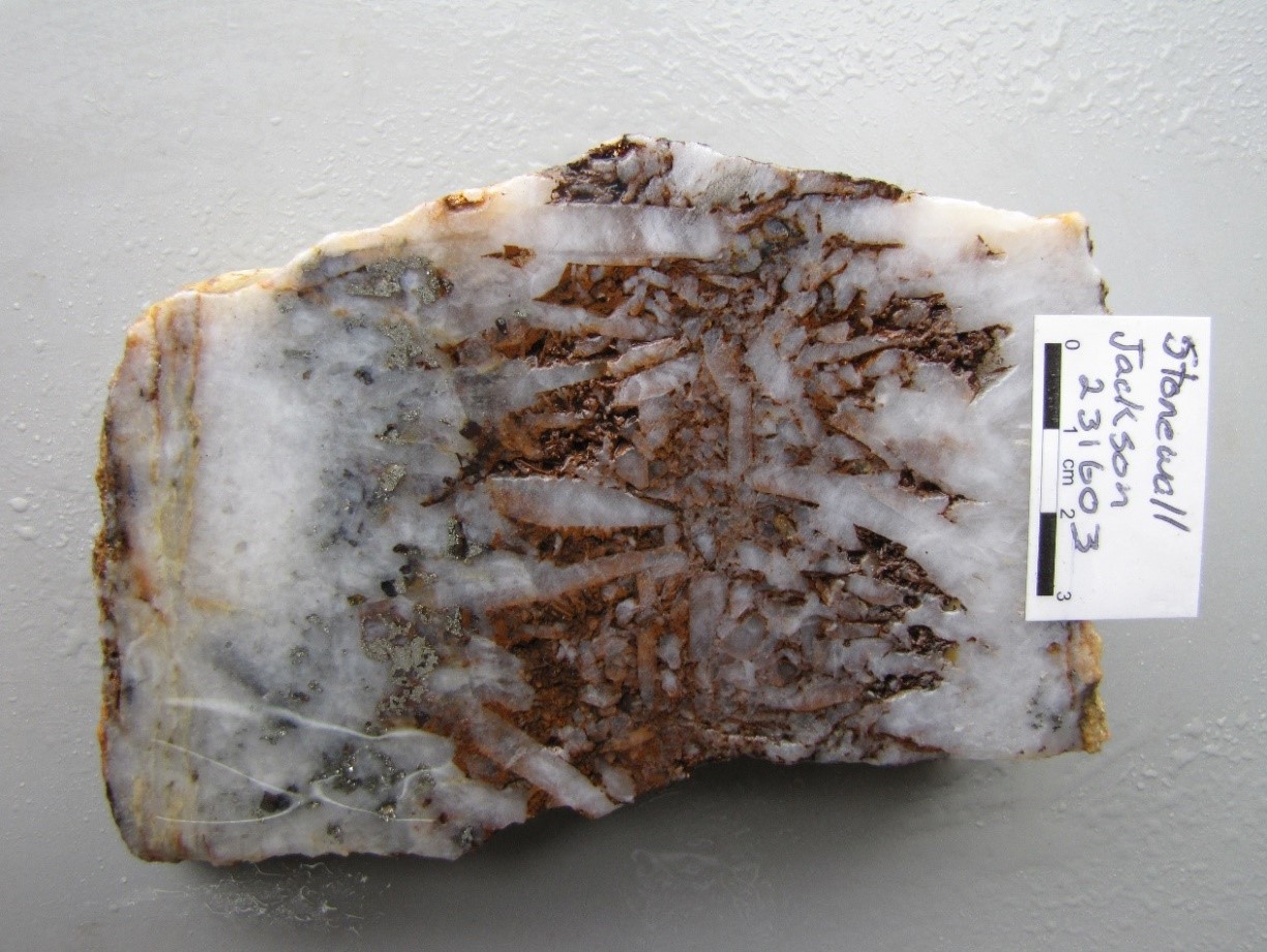PLATE 2: Quartz vein composed of clear to white, zoned, medium to coarse euhedral crystals growing perpendicular to vein walls giving a “comb” like appearance. Specimen of ore from the Stonewall Jackson Mine, International Camp (Georgetown). Sample #231603; 1.21 g/t Au, 7.53 g/t Ag.